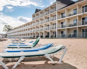 a row of lounge chairs on the beach in front of a hotel at Comfort Inn Lakeside in Mackinaw City