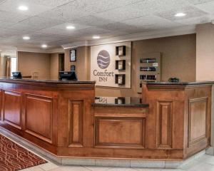 a lobby with a large wooden bar in a waiting room at Comfort Inn of Livonia in Livonia