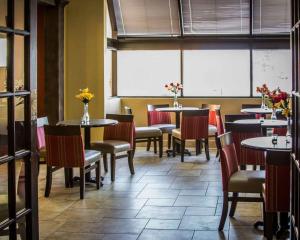 休倫港的住宿－Quality Inn & Suites，用餐室设有桌椅和窗户。