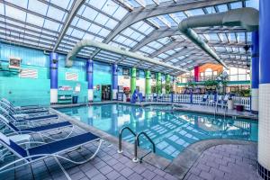 - une grande piscine avec des chaises dans un bâtiment dans l'établissement Country Inn & Suites by Radisson, Muskegon, MI, à Muskegon
