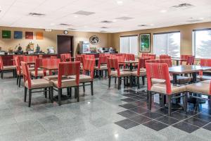 a restaurant with red chairs and tables in a room at Comfort Suites in Wixom