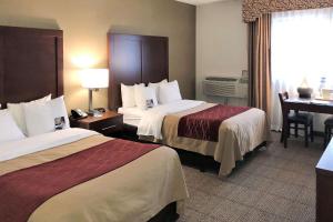 um quarto de hotel com duas camas e uma secretária em Comfort Inn Farmington Hills em Farmington Hills