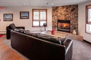 a living room with leather furniture and a stone fireplace at Econo Lodge On the Bay in Menominee