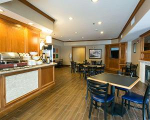 a kitchen and dining room with tables and chairs at Comfort Suites Benton Harbor - St. Joseph in Benton Harbor