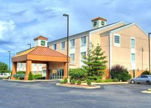 a large building with a car parked in a parking lot at Quality Inn Kalamazoo near Wings Stadium in Kalamazoo
