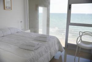 a bedroom with a bed with a view of the ocean at "Ninfas" in Puerto Madryn
