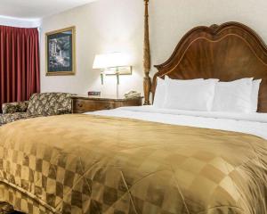 a hotel room with a large bed and a couch at Clarion Hotel Beachfront in Mackinaw City