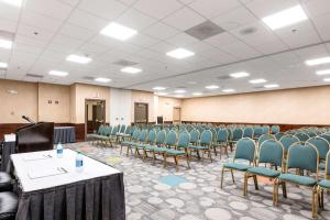 une salle de conférence avec des chaises et un podium dans l'établissement Clarion Hotel Detroit Metro Airport, à Romulus