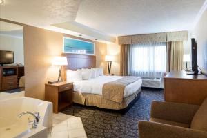 a hotel room with a bed and a bathroom at Clarion Hotel Detroit Metro Airport in Romulus