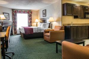 a large hotel room with a bed and a kitchen at Comfort Suites in Canton