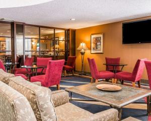 a waiting room with red chairs and a flat screen tv at Quality Inn Auburn Hills - Detroit North in Auburn Hills