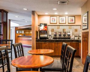 a restaurant with wooden tables and chairs and a bar at Quality Inn Auburn Hills - Detroit North in Auburn Hills
