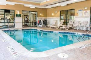 カントンにあるComfort Suites Canton - Detroitのホテルのプール(椅子、テーブル付)