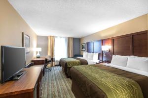 a hotel room with two beds and a flat screen tv at Comfort Inn Bay City - Riverfront in Bay City