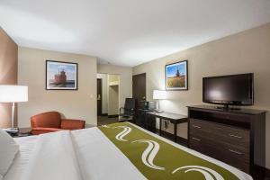 a hotel room with a bed and a flat screen tv at Quality Inn & Suites Holland in Holland