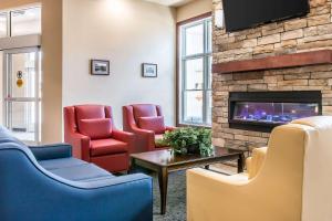 a waiting room with chairs and a fireplace at Quality Inn & Suites Houghton in Houghton