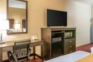 a hotel room with a television and a bed at Quality Inn & Suites Houghton in Houghton
