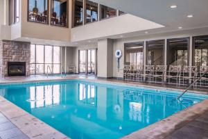 een zwembad met blauw water in een gebouw bij Shoreline Inn & Conference Center, Ascend Hotel Collection in Muskegon