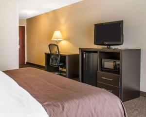 a hotel room with a bed and a flat screen tv at Quality Inn & Suites Niles in Niles