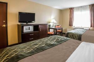 a hotel room with two beds and a flat screen tv at Econo Lodge Inn & Suites Monroe in Monroe