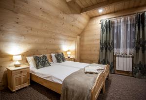 a bedroom with a bed in a wooden cabin at Osada Groń in Groń