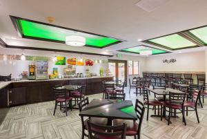 a restaurant with tables and chairs and a bar at Quality Inn & Suites Holland in Holland