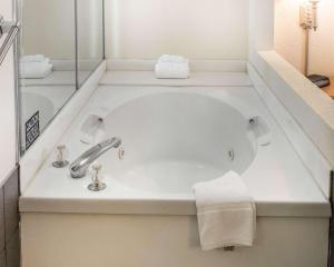 a bathroom with a bath tub with a sink at Quality Inn & Suites Monroe in Monroe