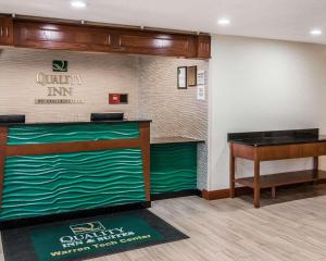 a hotel lobby with a desk and a piano at Quality Inn & Suites Warren - Detroit in Warren