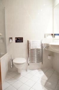 Baño blanco con aseo y lavamanos en Hotel Coronet, en Praga