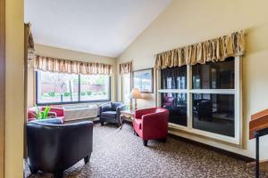 a living room with red chairs and windows at Rodeway Inn Red Wing in Red Wing