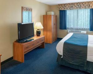a hotel room with a bed and a flat screen tv at Quality Inn Lakeville North in Lakeville