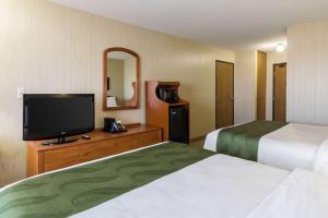 a hotel room with two beds and a flat screen tv at Quality Inn - Marshall in Marshall