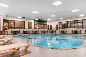una piscina en un hotel con mesas y sillas en Comfort Inn MSP Airport - Mall of America en Bloomington