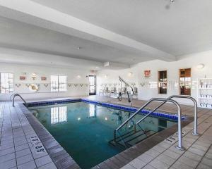 a large swimming pool with blue water in a building at Comfort Inn Owatonna near Medical Center in Owatonna
