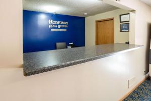 una oficina con un mostrador de recepción con una pared azul en Rodeway Inn & Suites Austin, en Austin