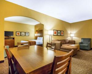 a hotel room with a table and a couch and a bed at Comfort Suites in Ramsey