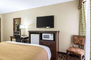 a hotel room with a bed and a flat screen tv at Quality Inn and Suites - Arden Hills in Arden Hills