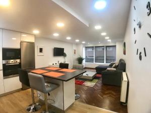 a kitchen and living room with a table and a couch at Dotombori in Oleiros