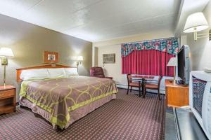 a hotel room with a bed and a flat screen tv at Rodeway Inn Saint Joseph in Saint Joseph