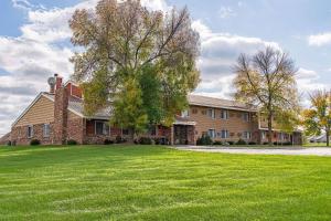 a large house with a large grass yard at Rodeway Inn in Saint Joseph