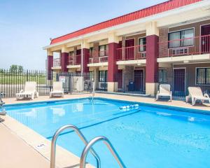 einen Pool in einem Hotel mit Stühlen und einem Gebäude in der Unterkunft Econo Lodge Kearney - Liberty in Kearney