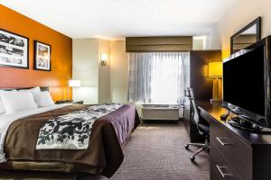 a hotel room with a bed and a flat screen tv at Sleep Inn Springfield South I60 near Medical District in Springfield