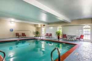 a swimming pool with red chairs and a table at Quality Inn & Suites Chesterfield Village in Springfield