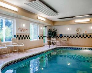 una piscina en una habitación de hotel con sillas y mesa en Comfort Suites Independence - Kansas City, en Independence