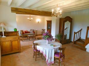 una sala de estar con una mesa con flores. en Auberge de la Tuilerie en Andryes