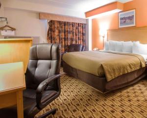 a hotel room with a bed and a chair at Econo Lodge Kansas City Downtown North in Kansas City