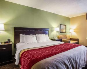 a hotel room with a large bed and a chair at Quality Inn Belton in Belton