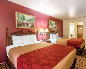 a hotel room with two beds and red walls at Econo Lodge Dexter in Dexter +9 photos