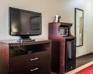 a flat screen tv on a dresser with a wooden entertainment center at Quality Inn Belton - Kansas City South in Belton