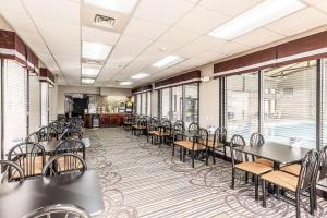 a dining room with tables and chairs and windows at Quality Inn in West Plains